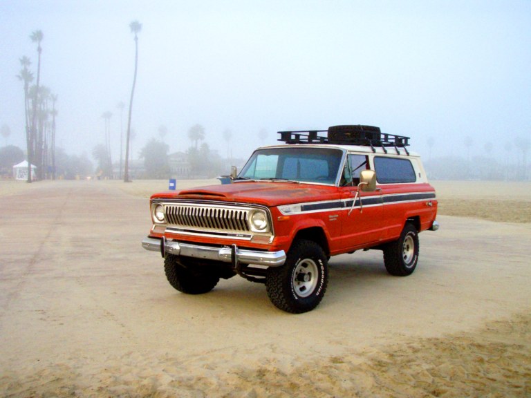 Jeep Cherokee S rouge de 1974, le tout premier millesime, gare sur une plage