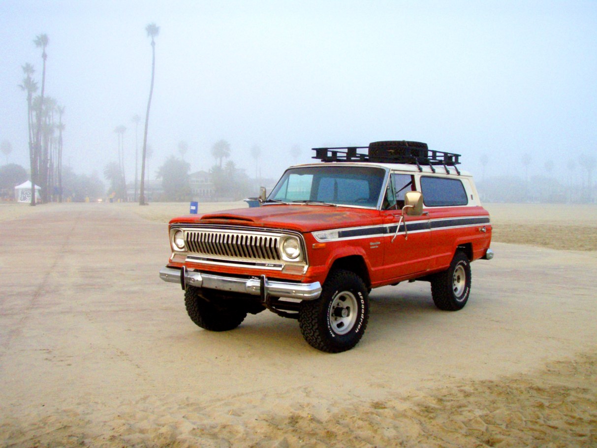 Jeep Cherokee S rouge de 1974, le tout premier millesime, gare sur une plage