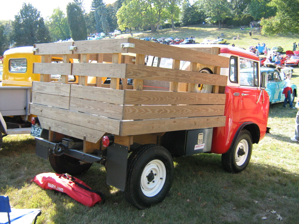 Jeep FC-150 avec plateau a ridelles en bois, vue arriere lors d’un rassemblement