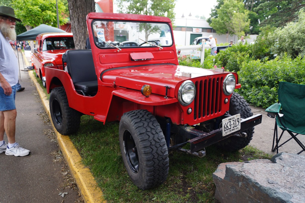 Willys CJ-3A rouge de 1949 avec son pare-brise en une seule piece lors d’un rassemblement